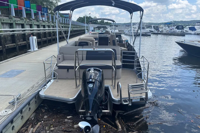 Slide: The Image of 2024 Harris Cruiser 230 pontoon boat docked at a marina, featuring a sleek design. - 5
