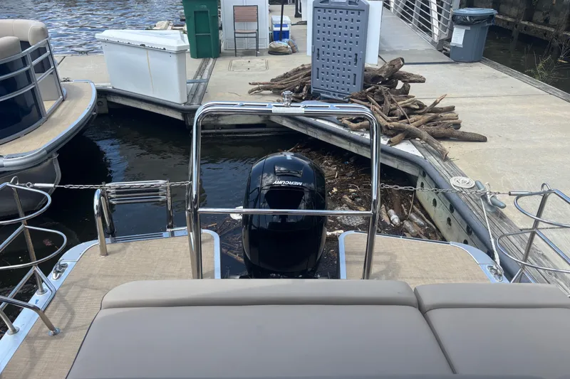 Slide: The Image of 2024 Harris Cruiser 230 pontoon boat docked with Mercury outboard motor. - 9