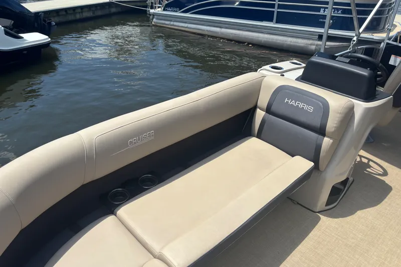 Slide: The Image of 2024 Harris Cruiser 230 boat interior with beige seating and cup holders. - 7