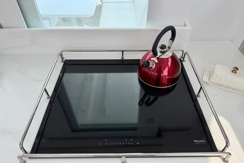 Slide: The Image of Modern kitchen with red kettle on Miele induction cooktop, Balance 526 model, 2025 design. - 43