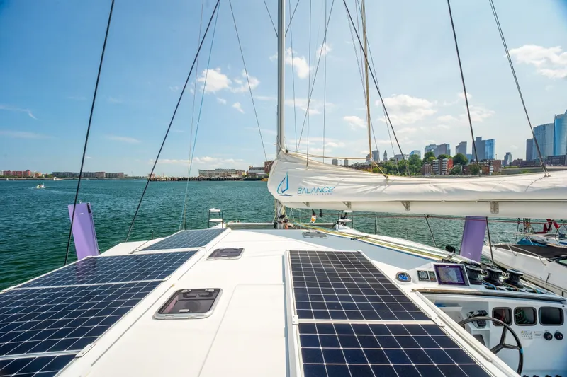 Slide: The Image of Sailing catamaran Balance 526 (2025) with solar panels, city skyline in background. - 15
