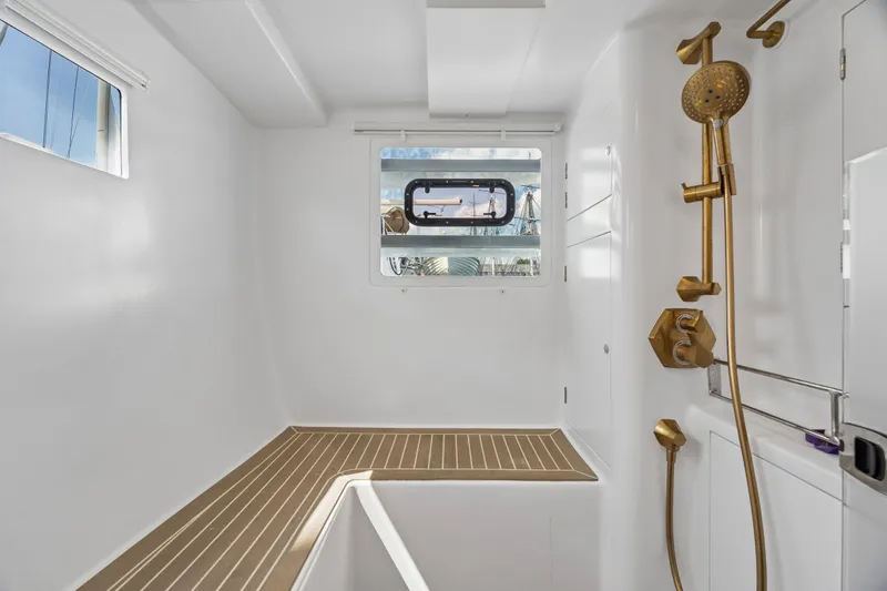 Slide: The Image of Modern yacht bathroom with gold fixtures, wooden flooring, and a window. Balance 526, 2025 model. - 64