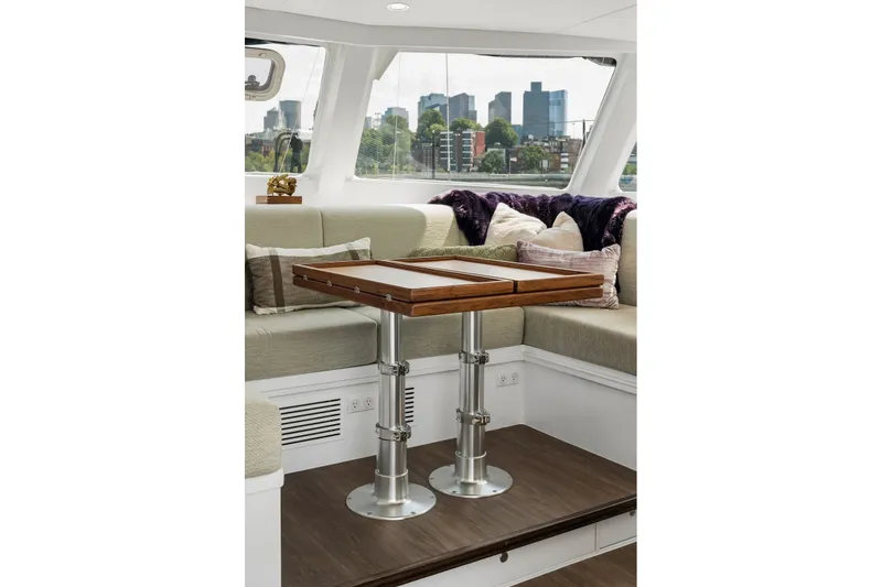 Slide: The Image of Luxurious interior of Balance 526 yacht, featuring a wooden table and plush seating, cityscape view. - 55