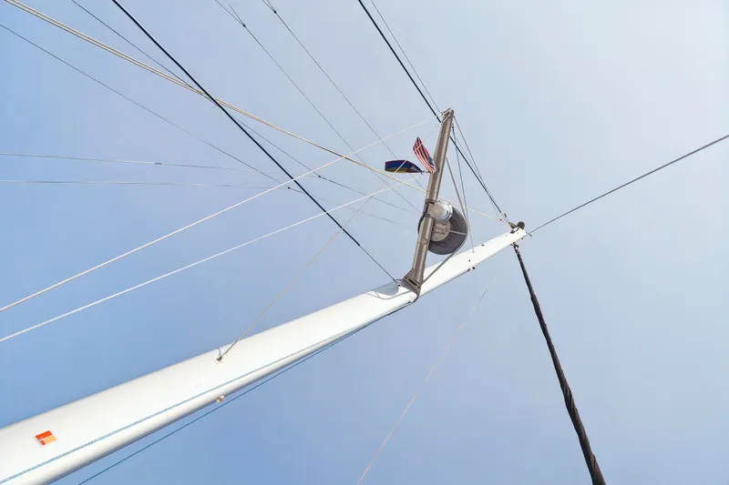 Slide: The Image of Sailboat mast with rigging and flags against clear sky, Balance 526, 2025 model. - 131