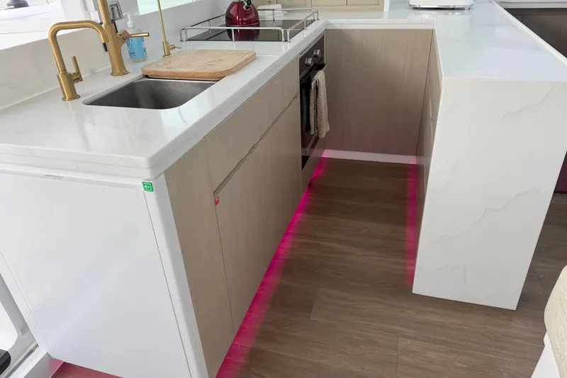 Slide: The Image of Modern kitchen with marble countertops, gold faucet, and pink LED lighting, Balance 526 model, 2025. - 108