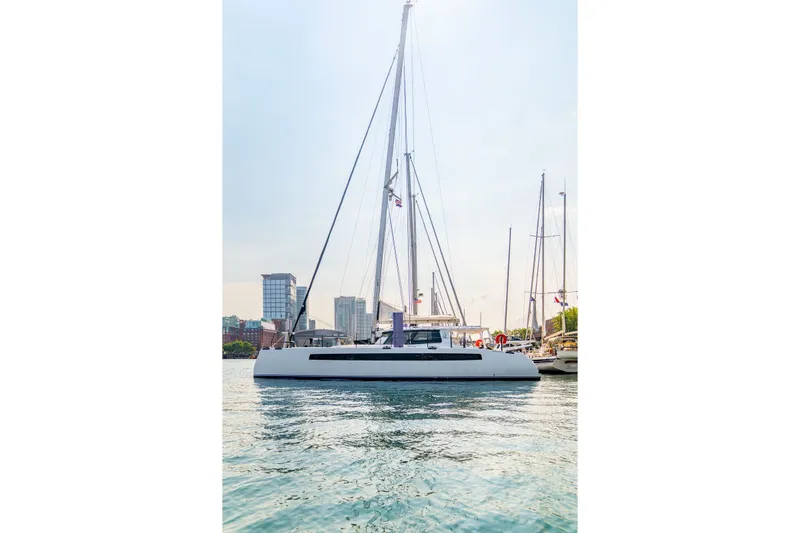 Slide: The Image of Modern Balance 526 catamaran sailing near city skyline, 2025 model. - 137