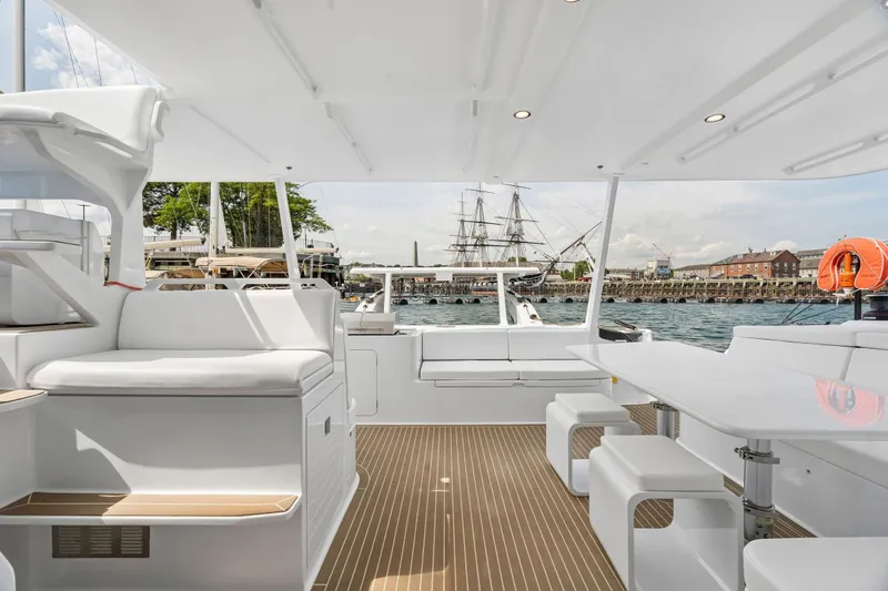 Slide: The Image of Modern Balance 526 yacht interior with sleek seating and table, overlooking a scenic harbor view. - 36