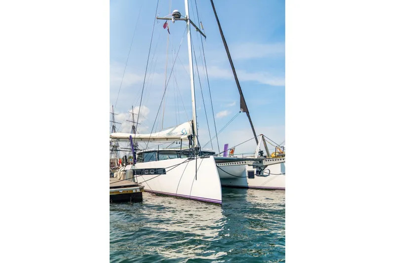 Slide: The Image of Modern Balance 526 catamaran docked in marina, 2025 model, under clear blue sky. - 138