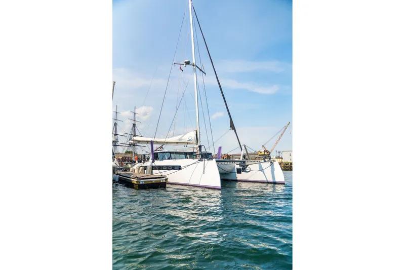 Slide: The Image of Modern Balance 526 catamaran docked in a marina, 2025 model, under clear blue skies. - 139