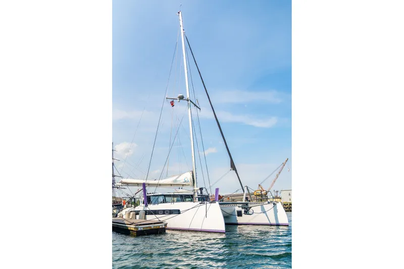 Slide: The Image of Sleek Balance 526 catamaran docked at a marina, 2025 model, under clear blue skies. - 140