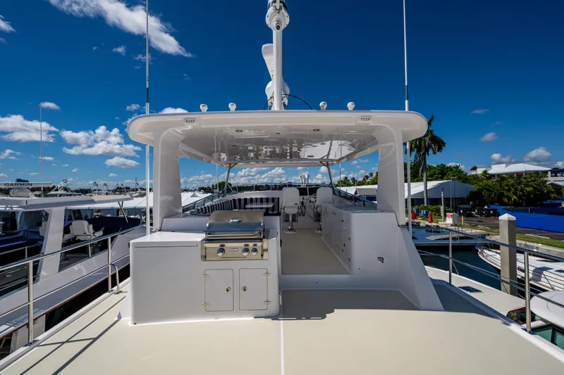 Slide: The Image of 2026 Kadey-Krogen 60 Open yacht deck with grill and seating under clear blue sky. - 86
