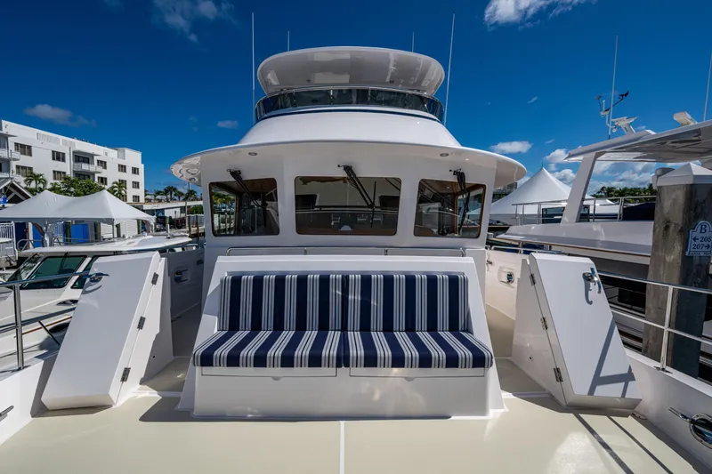 Slide: The Image of 2026 Kadey-Krogen 60 Open yacht with striped seating, docked under clear blue sky. - 82