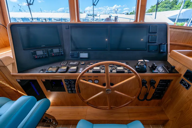 Slide: The Image of Pilothouse of 2026 Kadey-Krogen 60 Open yacht with advanced navigation systems and wooden steering wheel. - 21