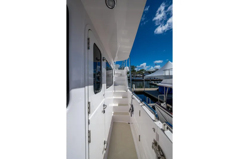 Slide: The Image of Side view of 2026 Kadey-Krogen 60 Open yacht, showcasing sleek design and marina backdrop. - 77