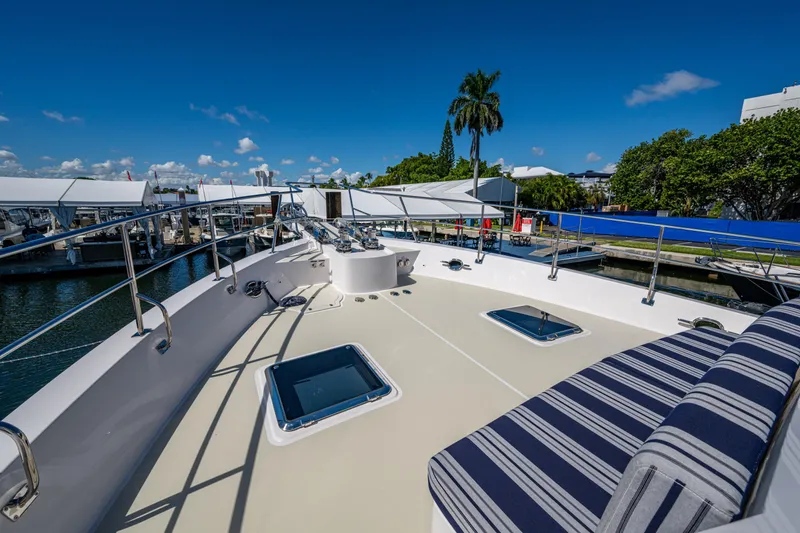 Slide: The Image of Luxurious Kadey-Krogen 60 Open yacht deck, 2026 model, with striped seating and marina view. - 85