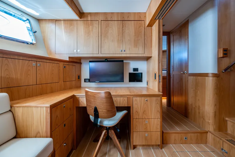 Slide: The Image of Luxurious wood-finished interior of 2026 Kadey-Krogen 60 Open yacht with desk and seating area. - 48