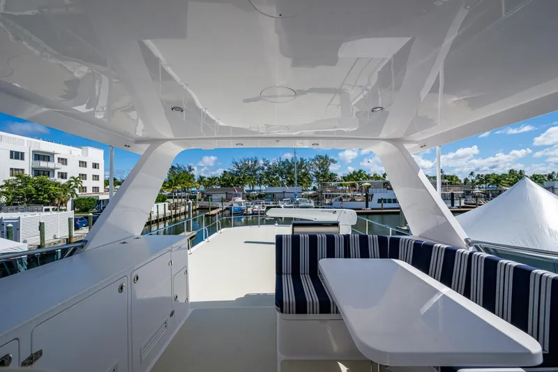 Slide: The Image of Luxurious 2026 Kadey-Krogen 60 Open yacht deck with striped seating and marina view. - 95