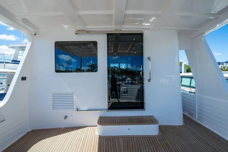 Slide: The Image of 2026 Kadey-Krogen 60 Open yacht deck with glass door and window. - 74