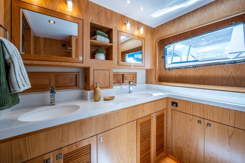 Slide: The Image of Luxurious bathroom in 2026 Kadey-Krogen 60 Open yacht with wooden cabinetry and dual sinks. - 33