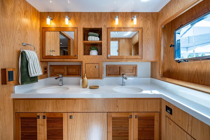 Slide: The Image of Luxurious Kadey-Krogen 60 Open 2026 yacht bathroom with dual sinks and wooden cabinetry. - 34