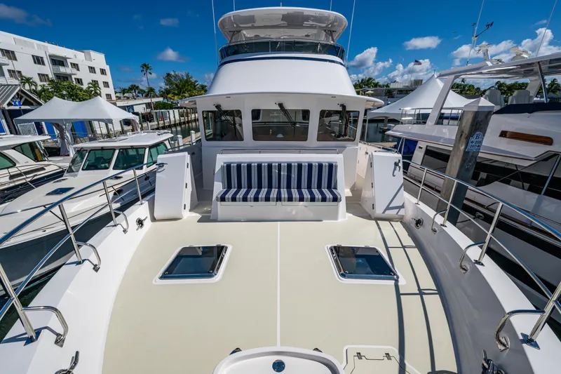 Slide: The Image of 2026 Kadey-Krogen 60 Open yacht with spacious deck and striped seating at marina. - 81