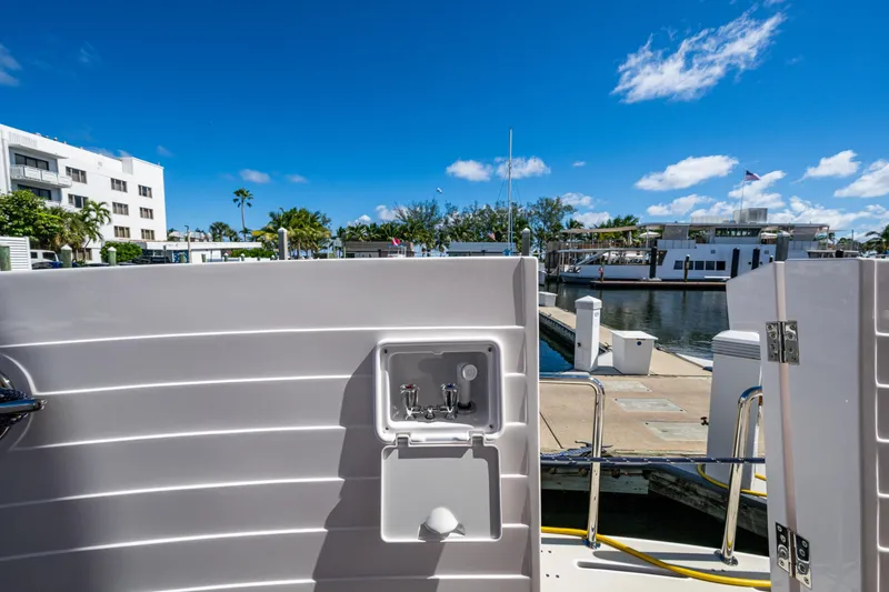 Slide: The Image of Kadey-Krogen 60 Open 2026 yacht docked at marina, featuring outdoor sink and clear blue sky. - 76