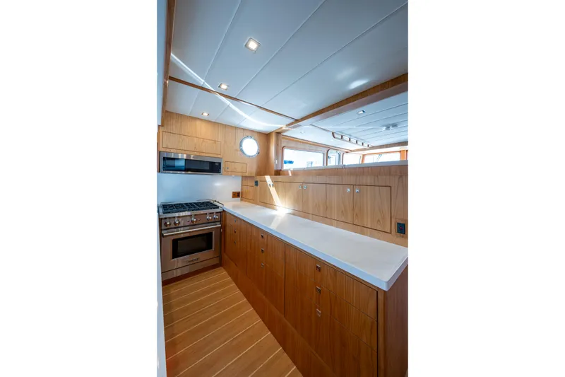 Slide: The Image of Modern kitchen interior of 2026 Kadey-Krogen 60 Open yacht, featuring wood cabinetry and stainless steel appliances. - 10