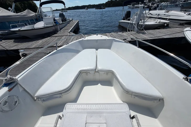 Slide: The Image of 2003 Hydra-Sports 180 CC boat interior with white seating at a marina dock. - 7