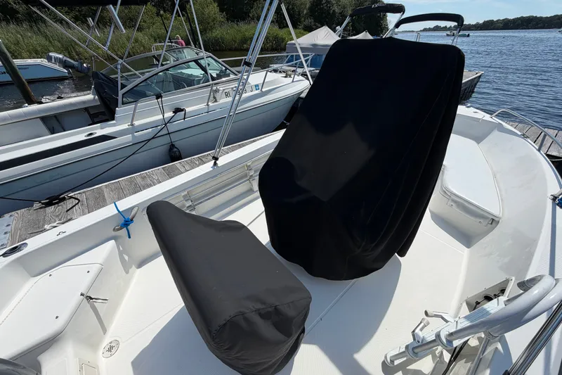 Slide: The Image of 2003 Hydra-Sports 180 CC boat interior with covered seats, docked by the water. - 6