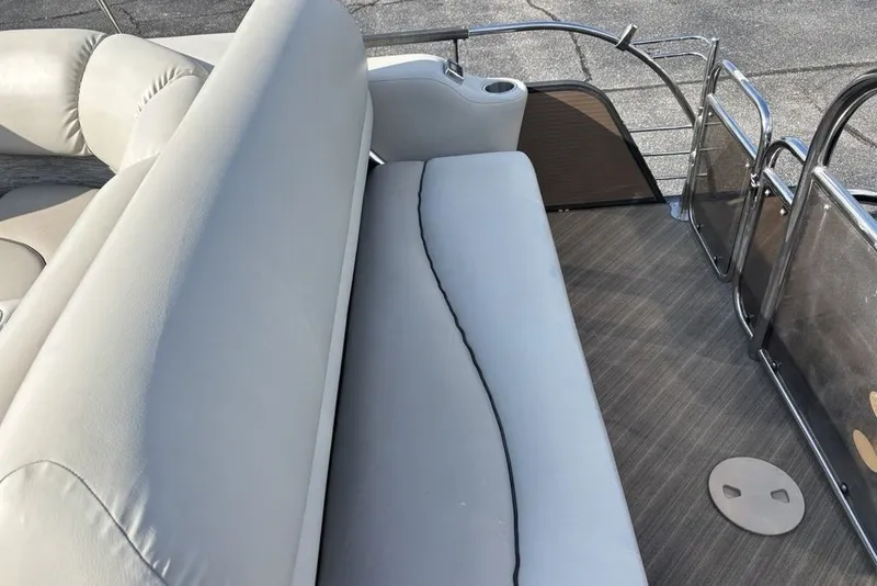 Slide: The Image of 2015 Manitou 25 SHP SES boat interior with cushioned seating and sleek flooring. - 15
