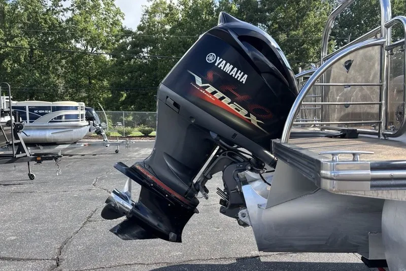 Slide: The Image of 2015 Manitou 25 SHP SES with Yamaha VMAX outboard motor in a parking lot. - 14