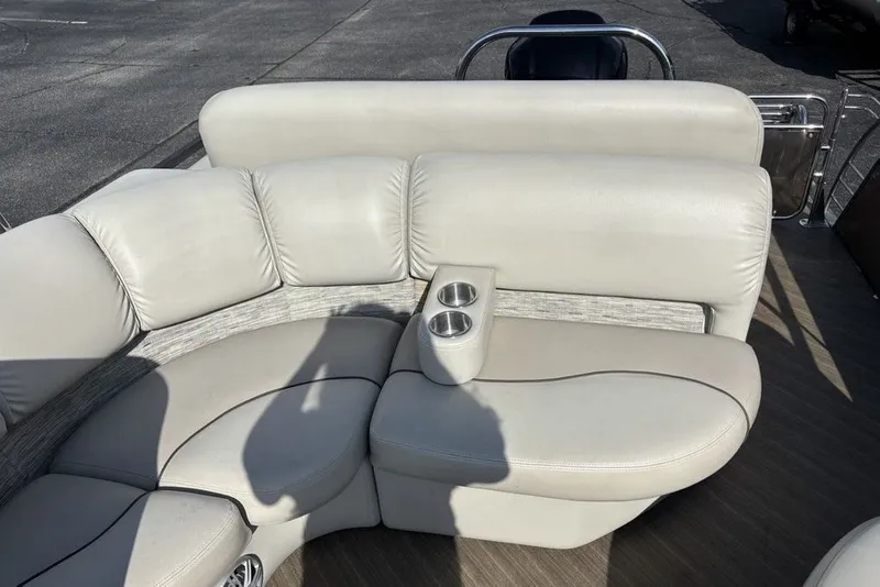 Slide: The Image of 2015 Manitou 25 SHP SES boat interior with beige seating and cup holders. - 20