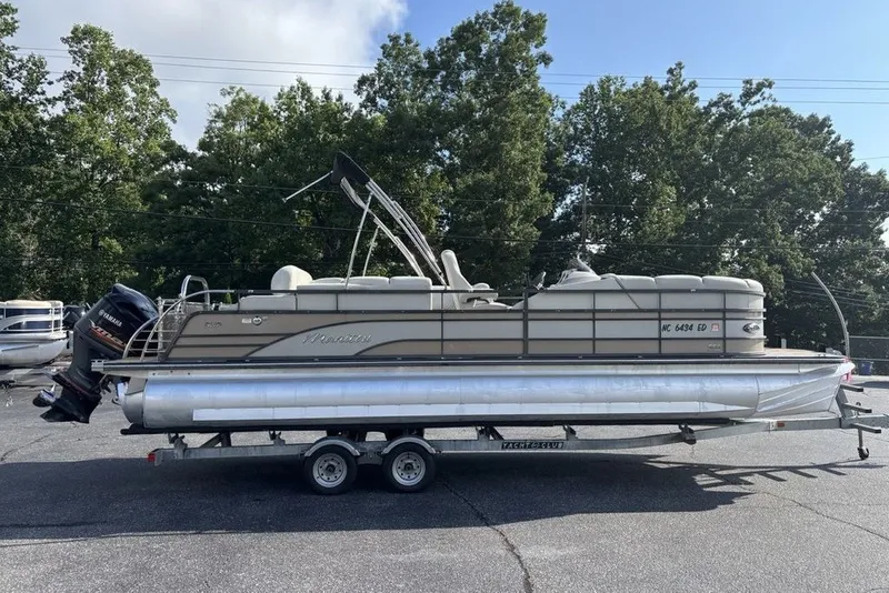 Slide: The Image of 2015 Manitou 25 SHP SES pontoon boat on trailer, parked outdoors. - 18