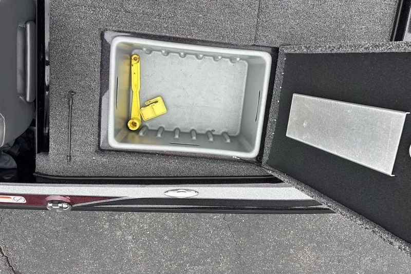 Slide: The Image of Open storage compartment in 2021 Nitro Z21 boat with yellow tool inside. - 39