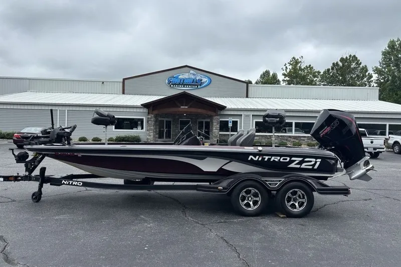 The Image of 2021 Nitro Z21 boat on trailer outside a marine center, showcasing sleek design. - 1