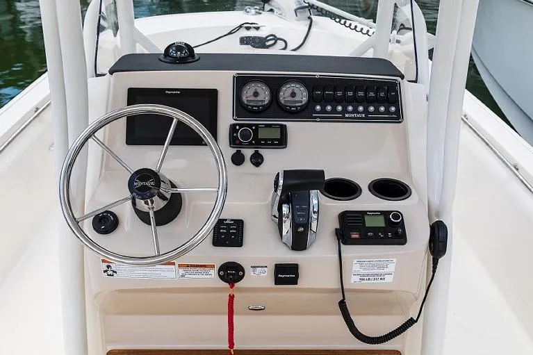 Slide: The Image of Manufacturer Provided Image: 2023 Boston Whaler 210 Montauk boat console with steering wheel and navigation controls. - 19
