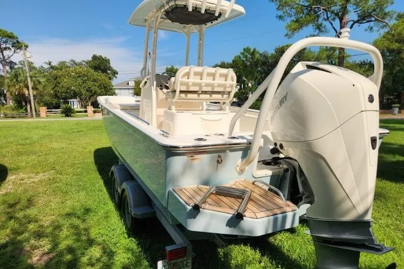 Slide: The Image of 2023 Boston Whaler 210 Montauk boat on trailer, parked on grass. - 2