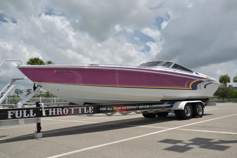 The Image of 2006 Formula 353 FASTech speedboat on trailer, vibrant pink and white design, parked outdoors. - 0