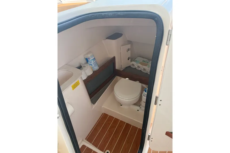 Slide: The Image of 2024 Grady-White Freedom 285 boat interior with compact marine toilet and storage. - 17