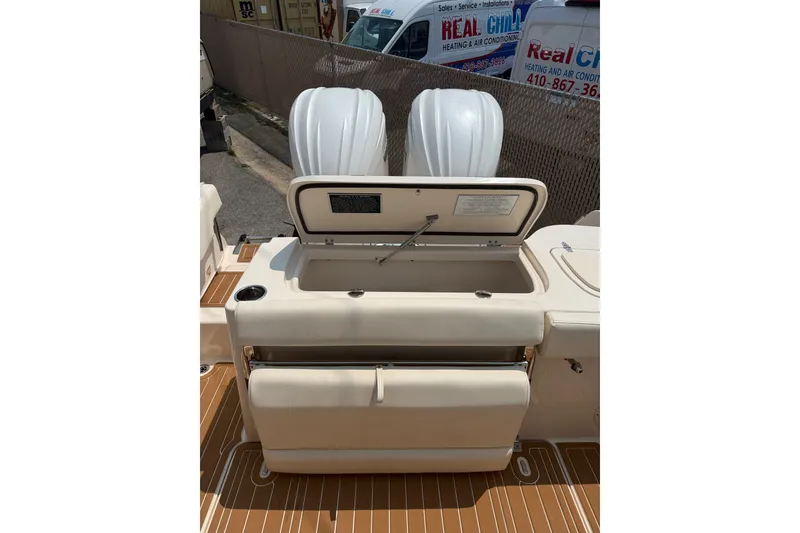 Slide: The Image of 2024 Grady-White Freedom 285 boat interior with open storage compartment and twin engines. - 11