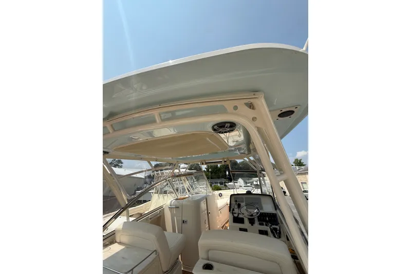 Slide: The Image of 2024 Grady-White Freedom 285 boat interior with helm and seating under a clear sky. - 3