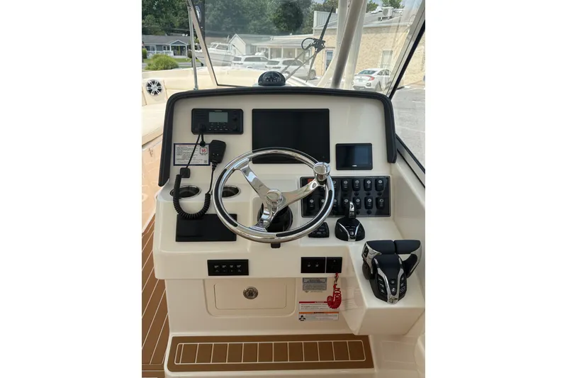 Slide: The Image of 2024 Grady-White Freedom 285 helm with steering wheel and control panel. - 16