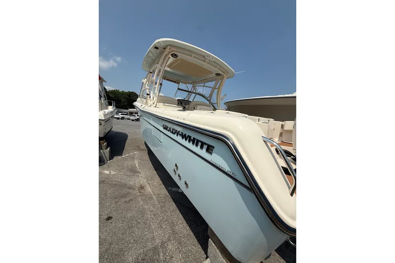 Slide: The Image of 2024 Grady-White Freedom 285 boat with sleek design, docked under clear blue sky. - 10