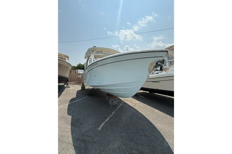 Slide: The Image of 2024 Grady-White Freedom 285 boat displayed outdoors under a clear sky. - 6