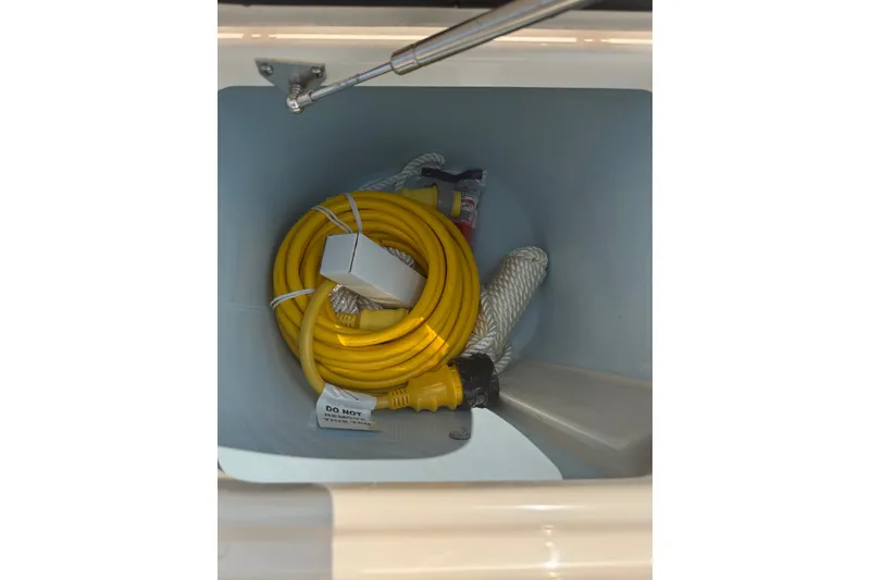 Slide: The Image of Storage compartment in 2024 Grady-White Freedom 285 boat with yellow hose and rope. - 22