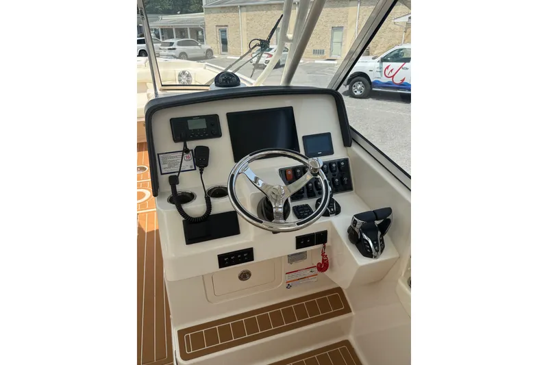 Slide: The Image of 2024 Grady-White Freedom 285 helm with steering wheel, controls, and navigation equipment. - 15
