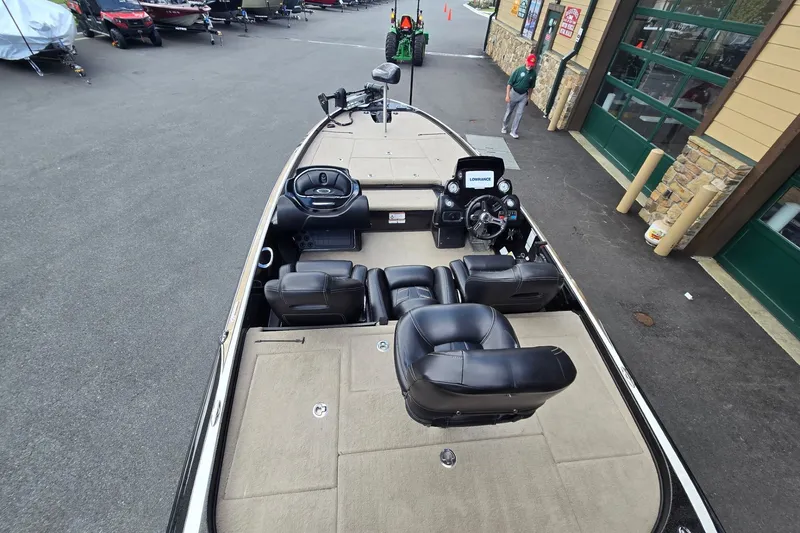 Slide: The Image of 2016 Nitro Z21 boat interior with black seats and steering console, parked outside a building. - 6