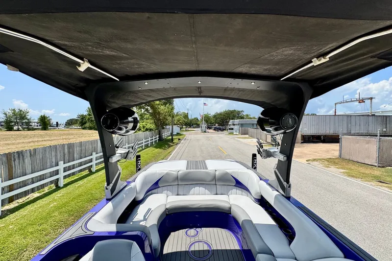 Slide: The Image of 2018 MB F24 Tomcat boat with spacious seating and speakers, parked on a sunny day. - 9