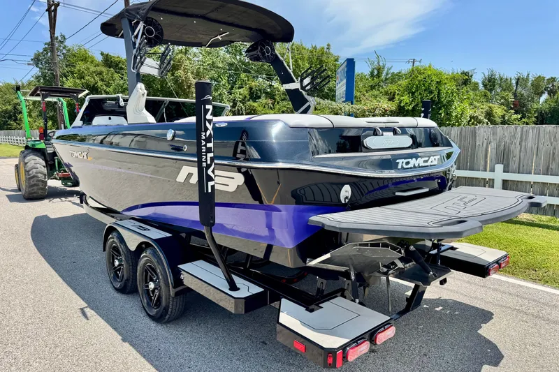 Slide: The Image of 2018 MB F24 Tomcat boat on trailer, sleek design, parked outdoors. - 2