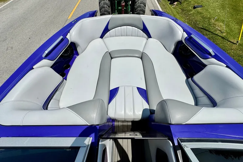 Slide: The Image of 2018 MB F24 Tomcat boat interior with white and blue seating on a road. - 15